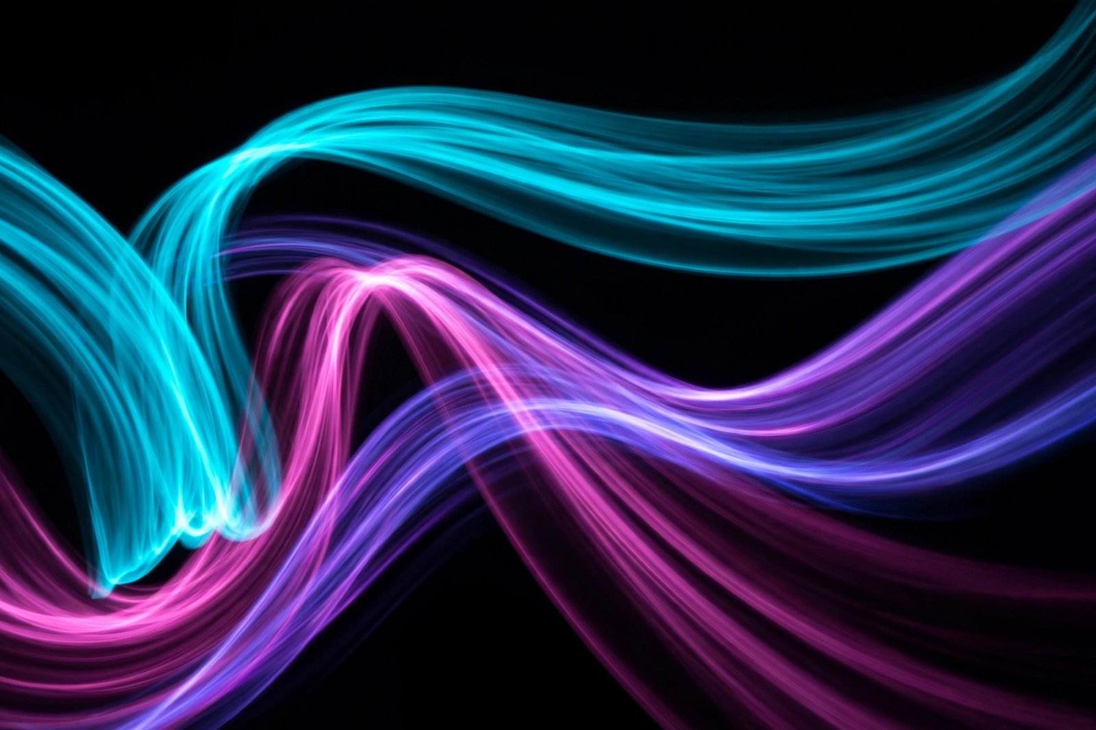  "Cyan and magenta neon light trails sweeping across black"