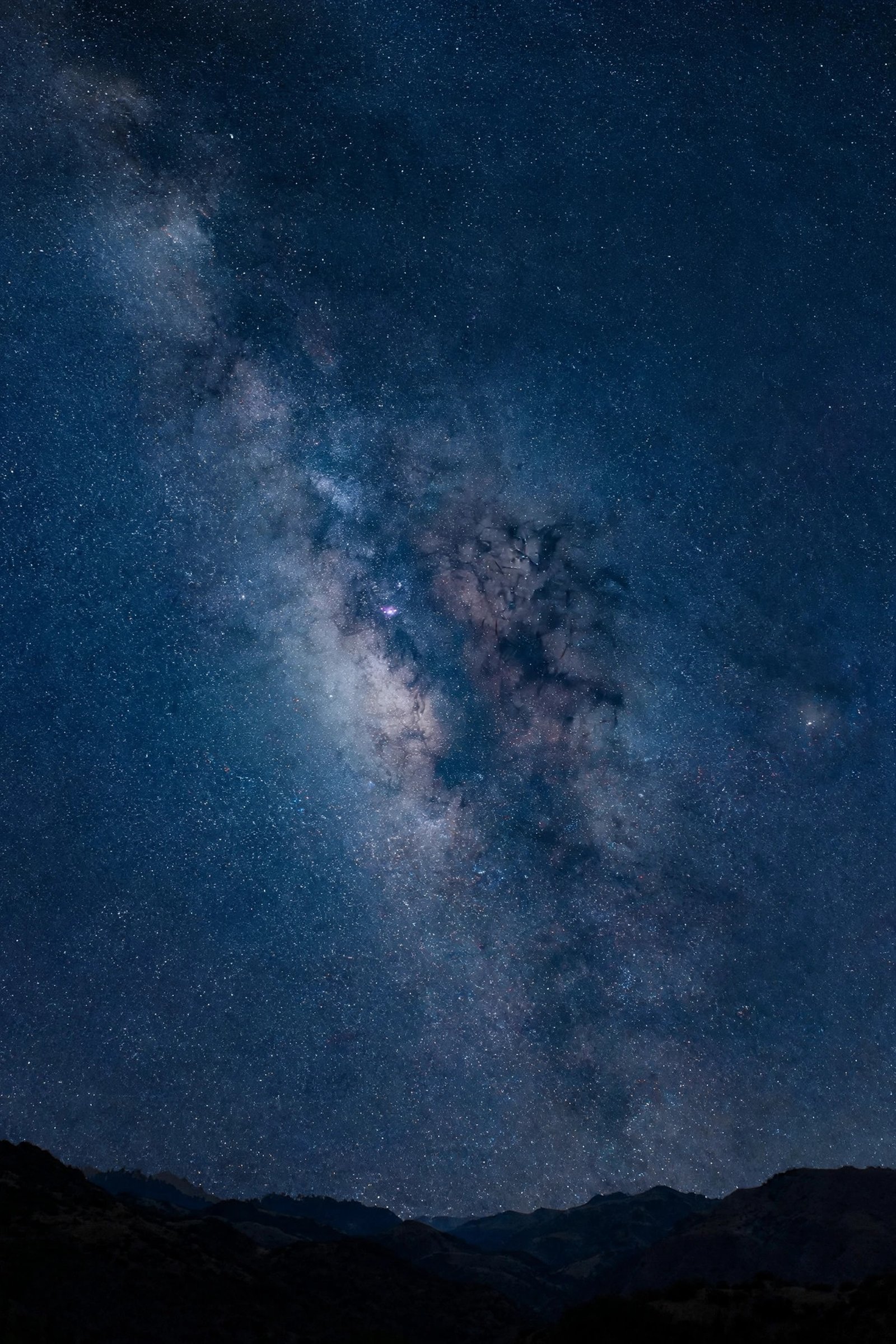  "Starry night sky with the milky way over dark hills"