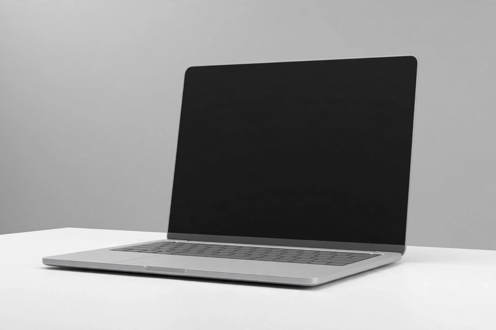 "Generic laptop with blank screen on a minimal white desk in a studio"